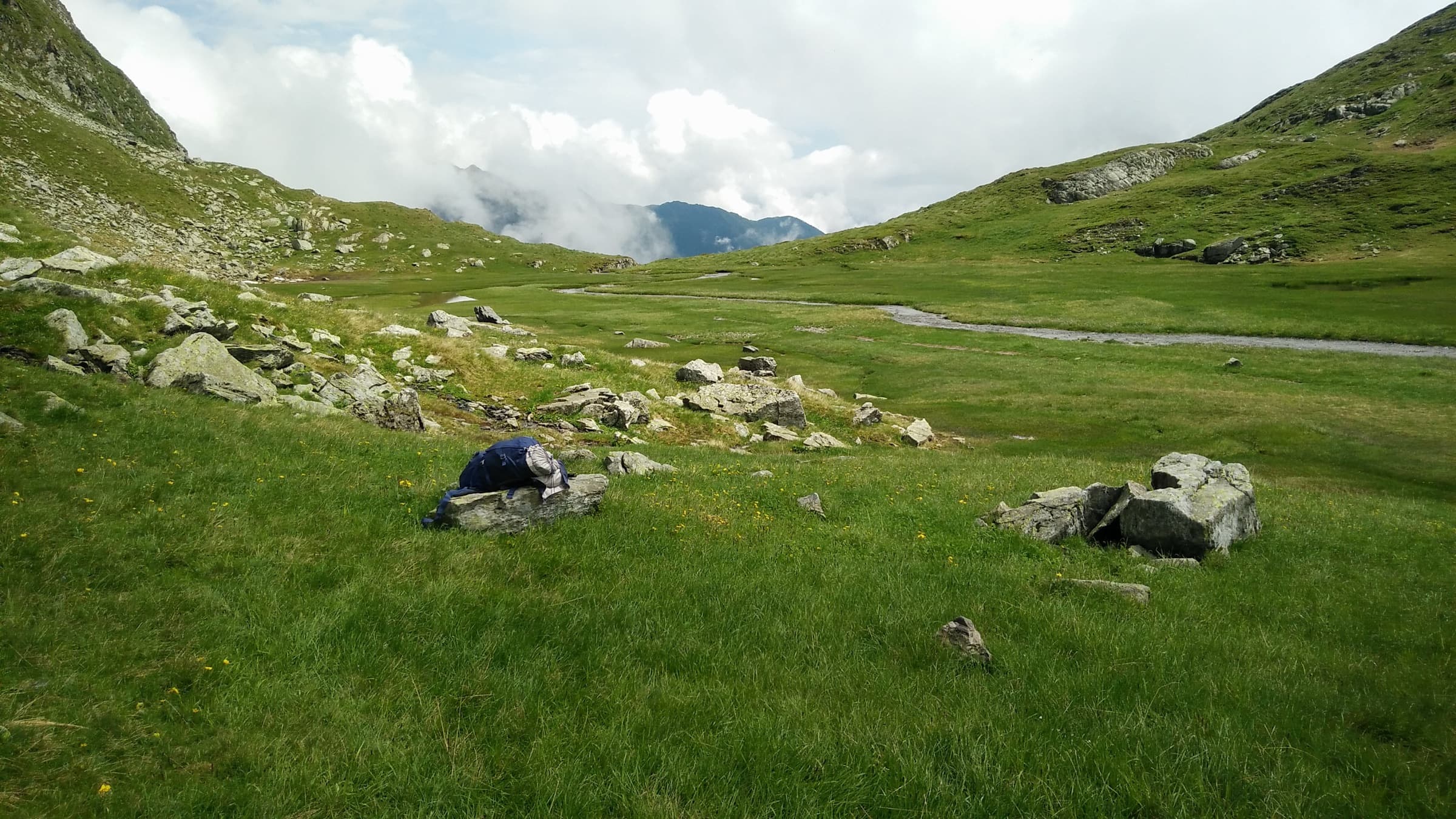 Rolling green pastures in a high valley under low cloud