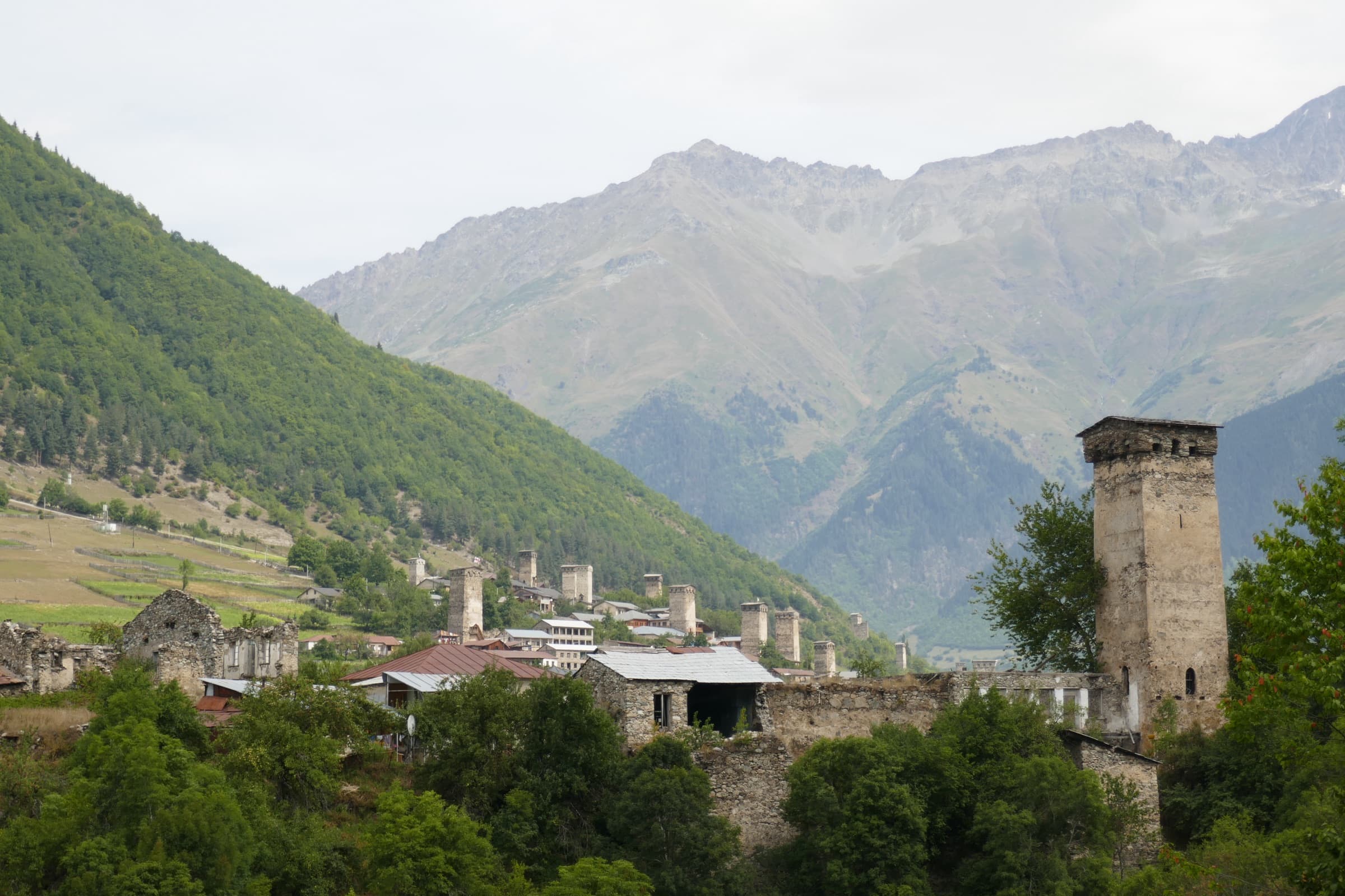 Medieval stone defence towers rising above a green mountain village