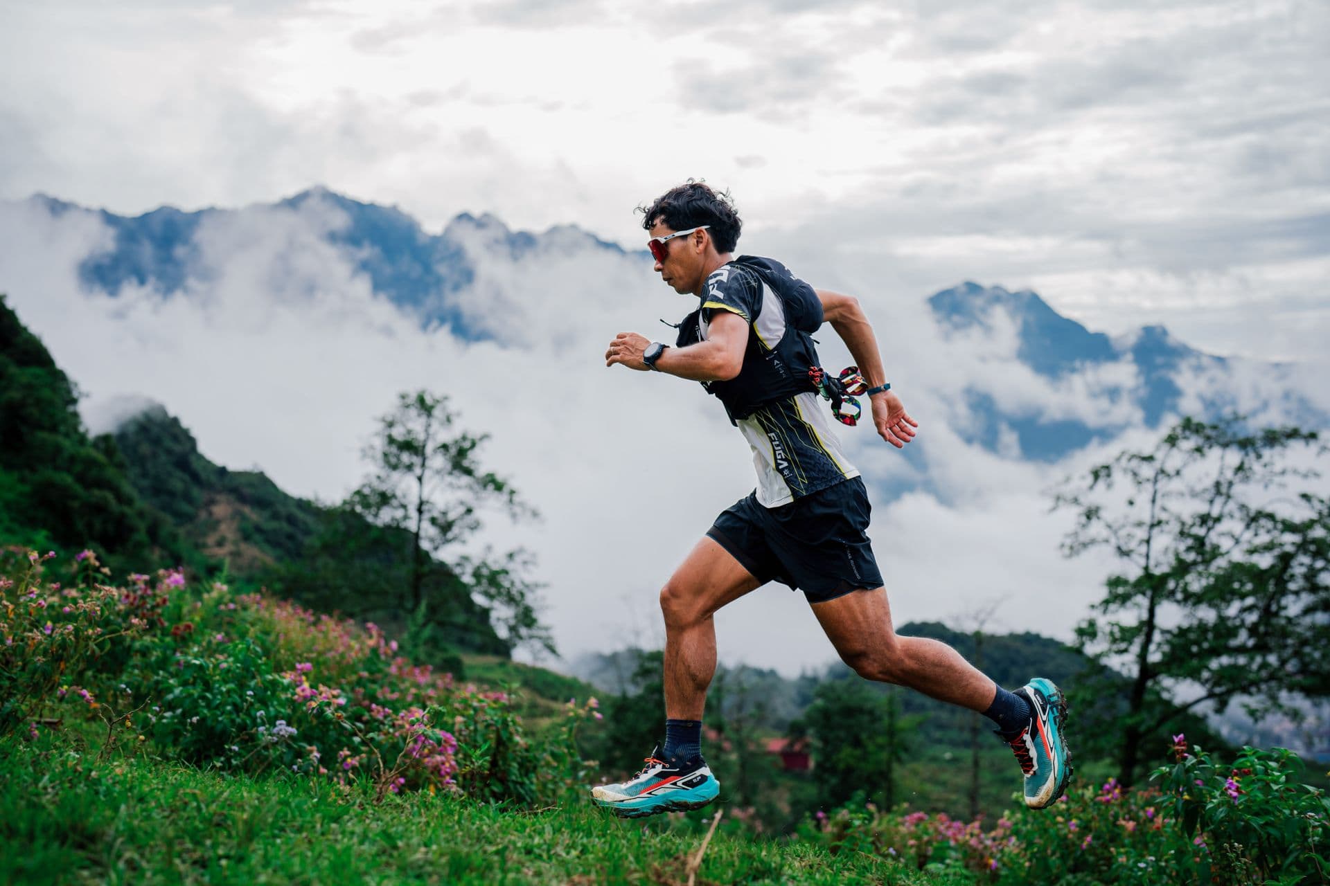 Trail runner climbing a grassy mountain ridge, the kind of run the Shokz OpenRun Pro 2 review covers