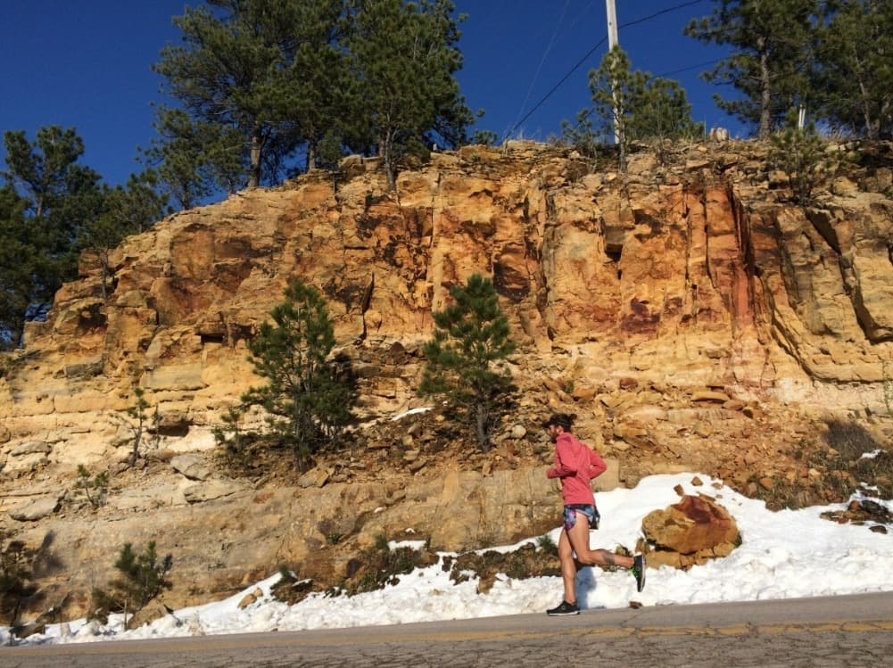 Trail running shoes for hiking on a rocky mountain trail, showing lug tread and lightweight construction