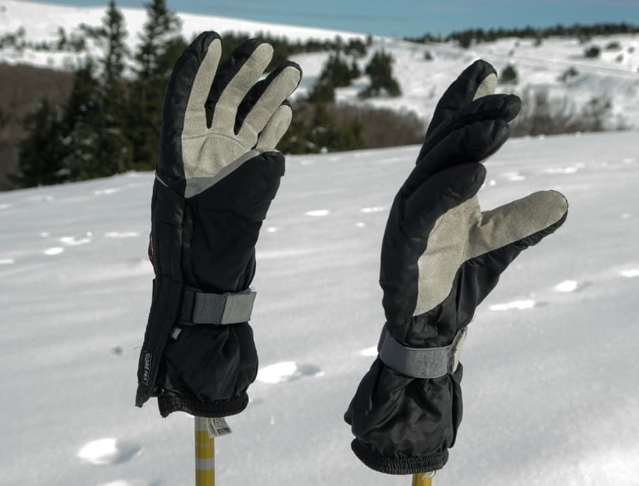 Hiker wearing waterproof hiking gloves in snowy mountain conditions